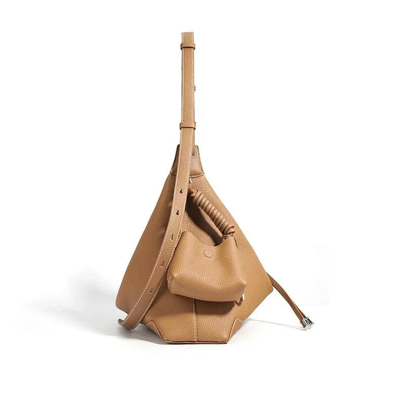 Tan leather geometric handbag with adjustable strap on white background