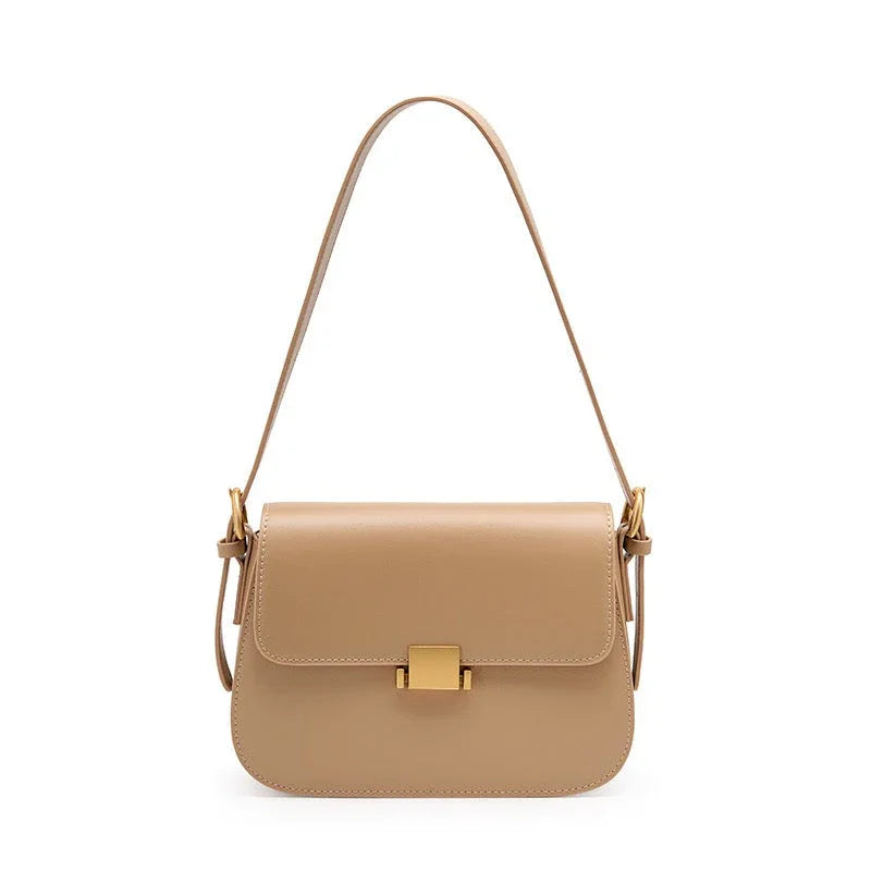 Beige leather shoulder bag with gold clasp and adjustable strap on white background