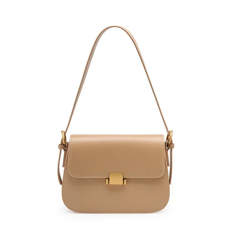 Beige leather shoulder bag with gold clasp and adjustable strap on white background