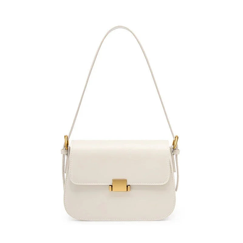 White leather shoulder bag with gold clasp and hardware on a white background