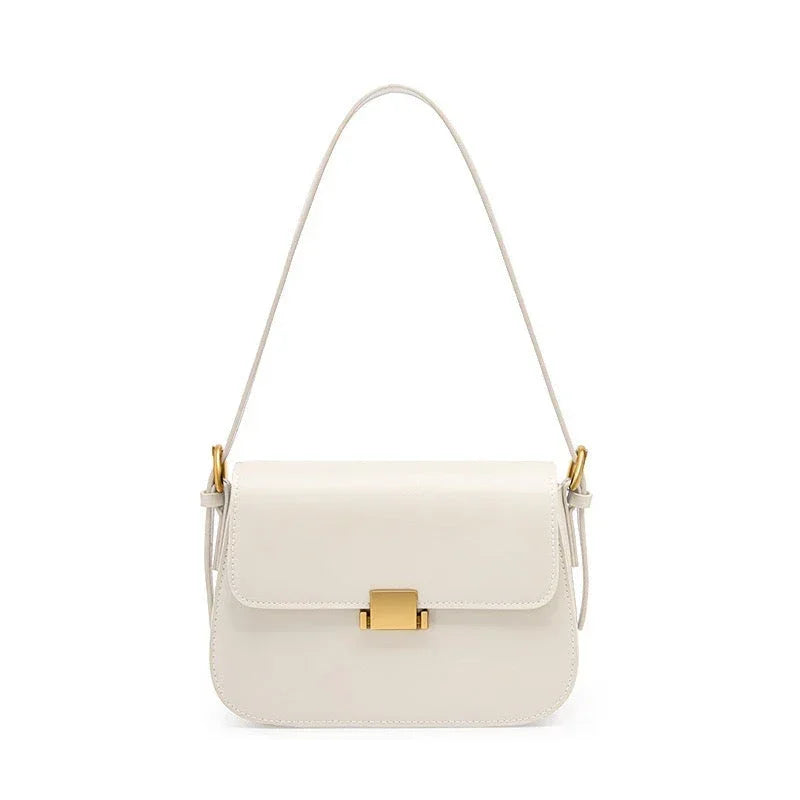 White leather shoulder bag with gold clasp and hardware on a white background