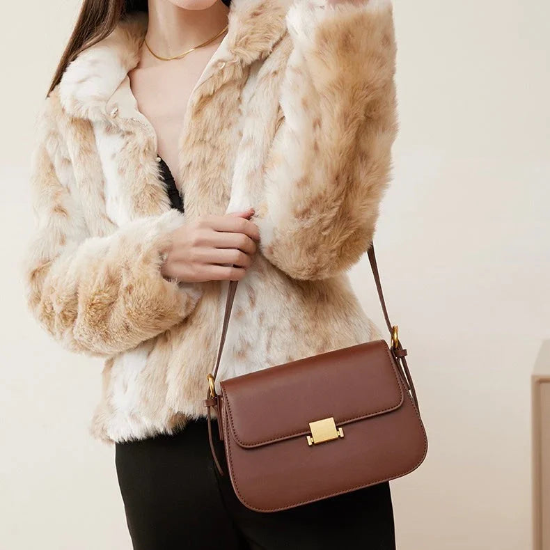 Woman in faux fur jacket with brown leather shoulder bag and gold clasp