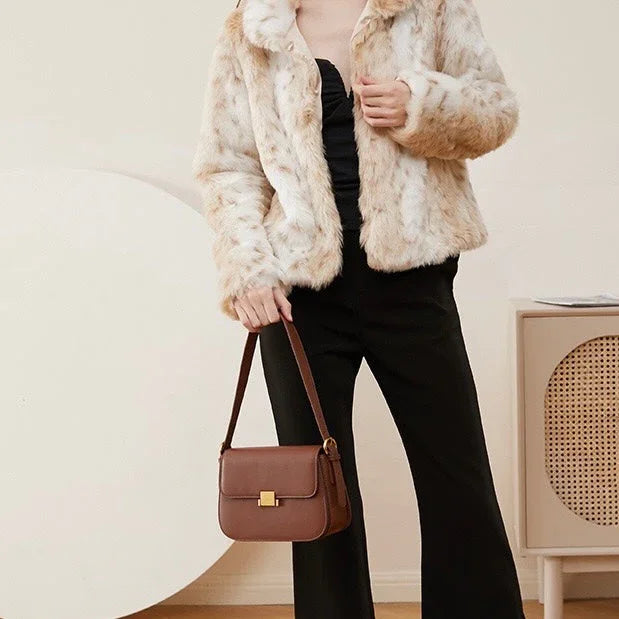 Woman in faux fur jacket with brown shoulder bag and black pants in modern room