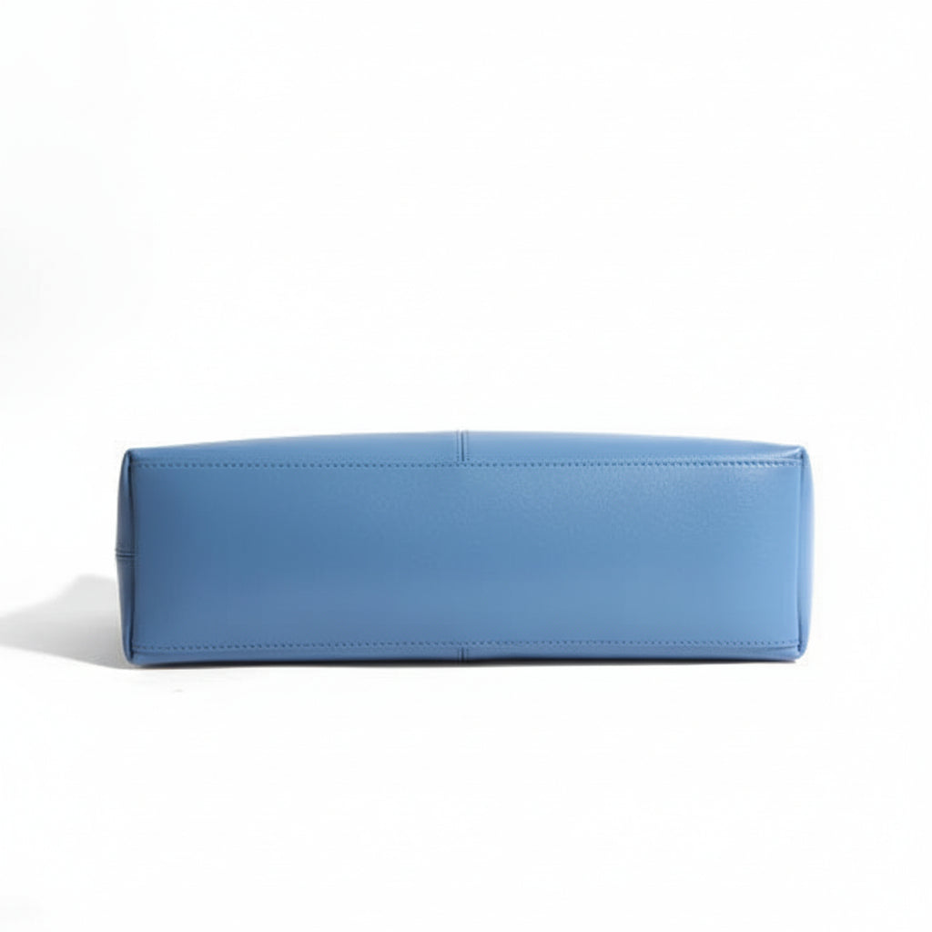 Bottom view of a rectangular blue leather handbag on a white background