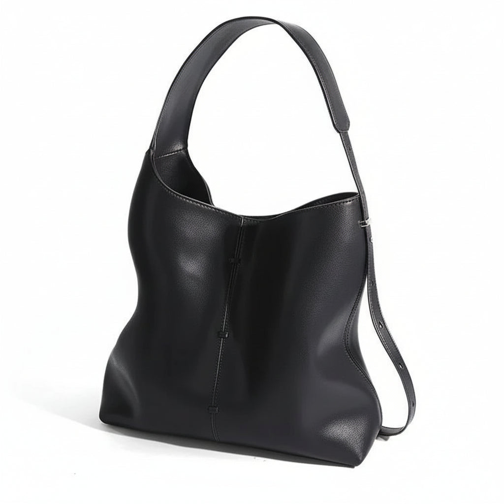 Black leather shoulder bag with wide strap and minimalist design on white background