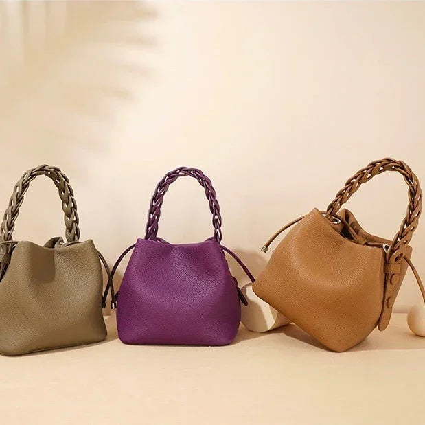Three braided handle handbags in olive green, purple, and tan on a beige background