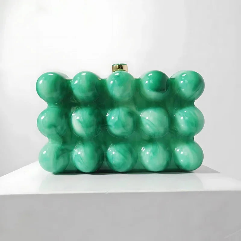Green bubble textured clutch purse with marble effect on white display stand
