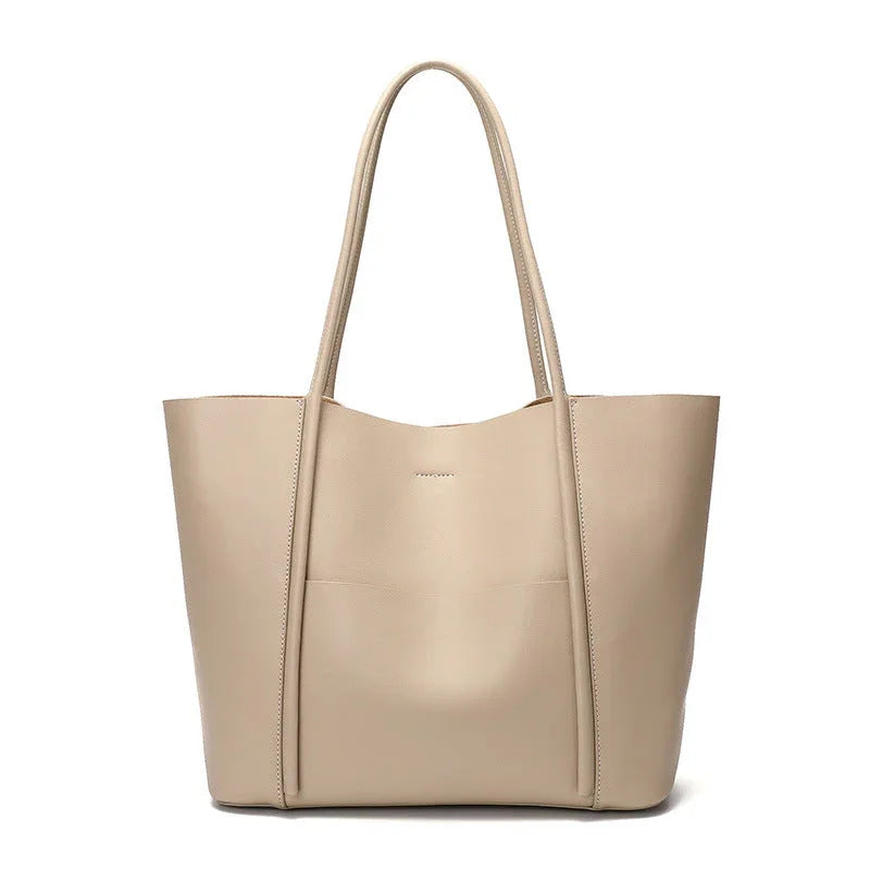 Beige leather tote bag with long handles, minimalist design, on white background