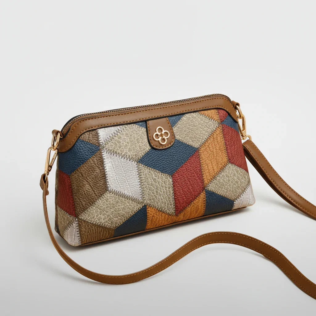 Geometric patchwork leather crossbody bag with brown strap on a beige background