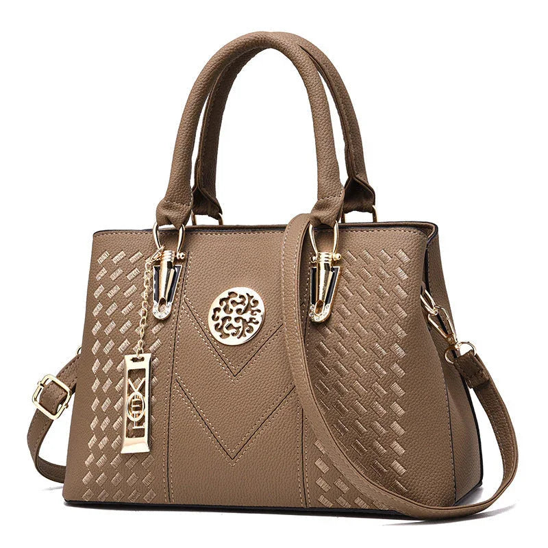 Elegant brown leather handbag with gold accents and textured geometric pattern