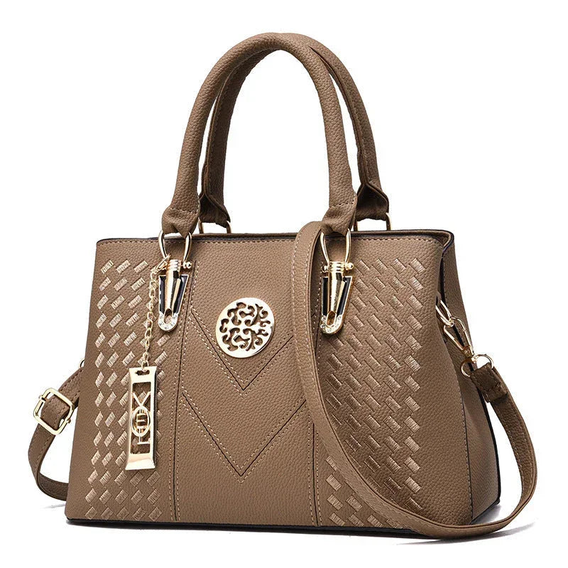 Elegant brown leather handbag with gold accents and textured geometric pattern