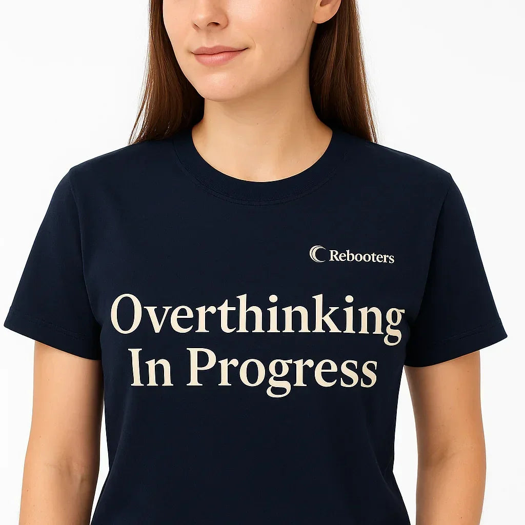 Person wearing a navy blue t-shirt with 'Overthinking In Progress' text and 'Rebooters' logo.
