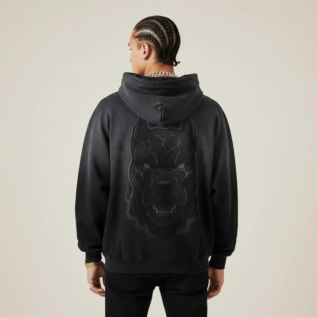 Person wearing a black hoodie with a Pitbull dog graphic on the back against a plain background | Rebooters