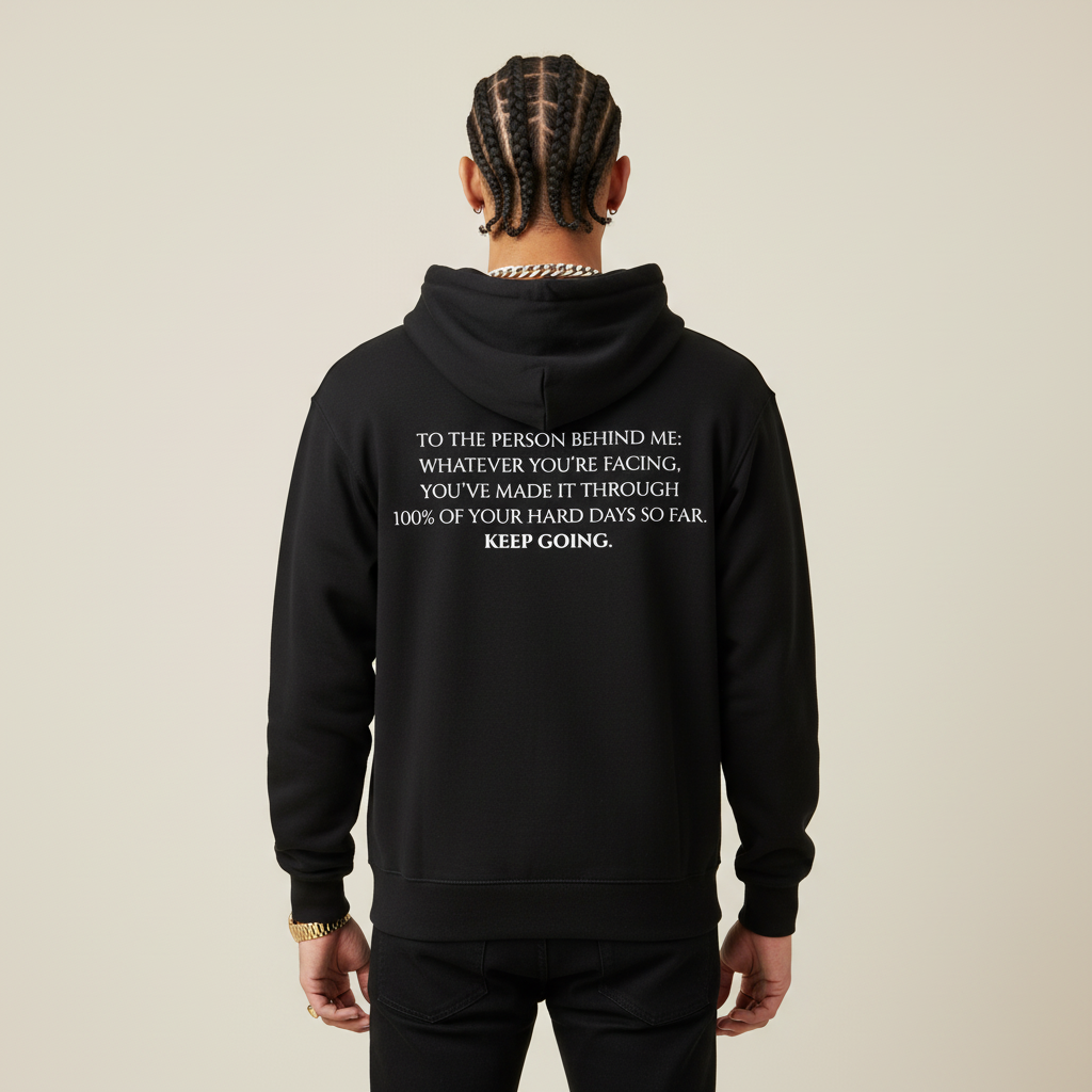 Black hoodie with motivational text on the back against a light gray background