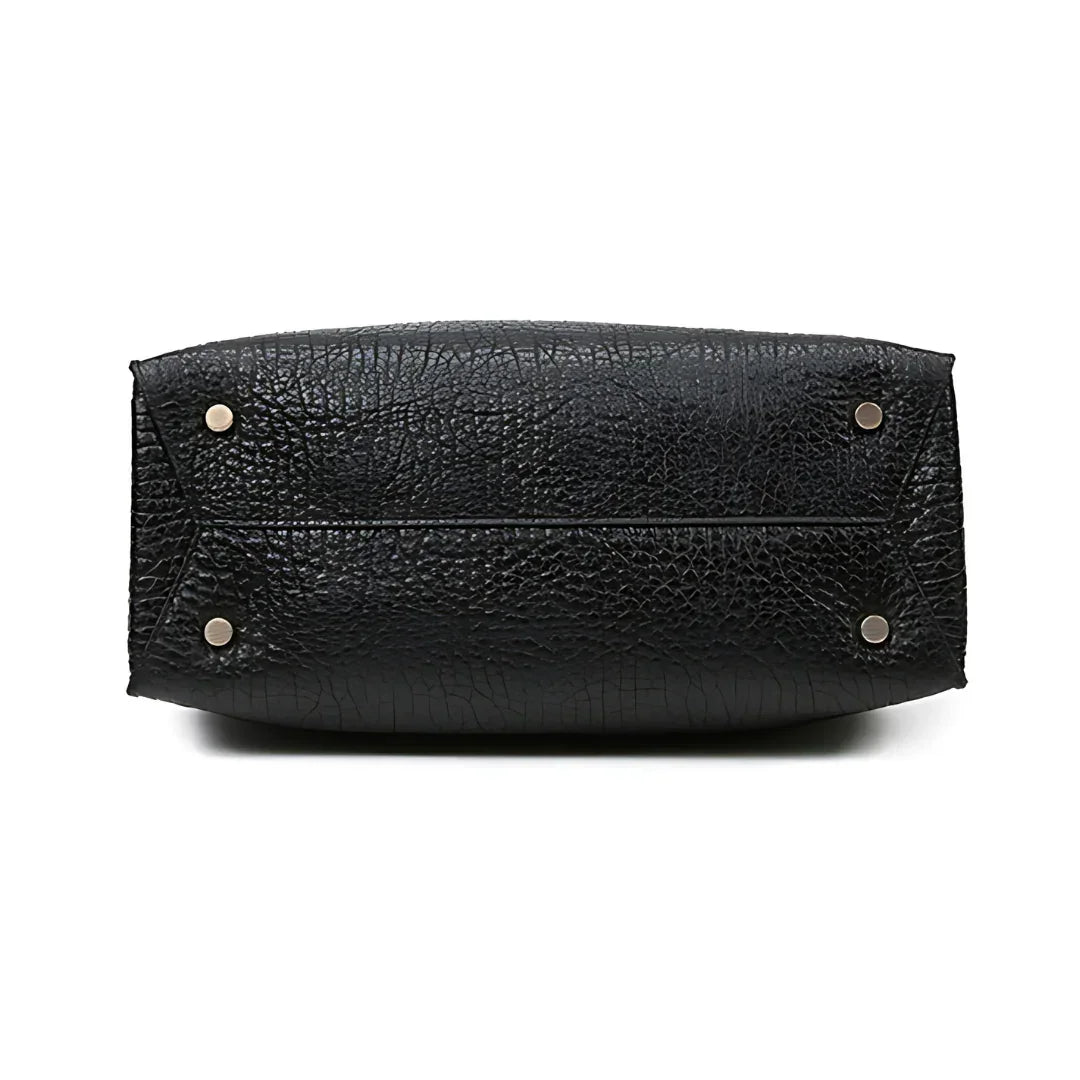 Bottom view of black textured leather handbag with silver metal feet