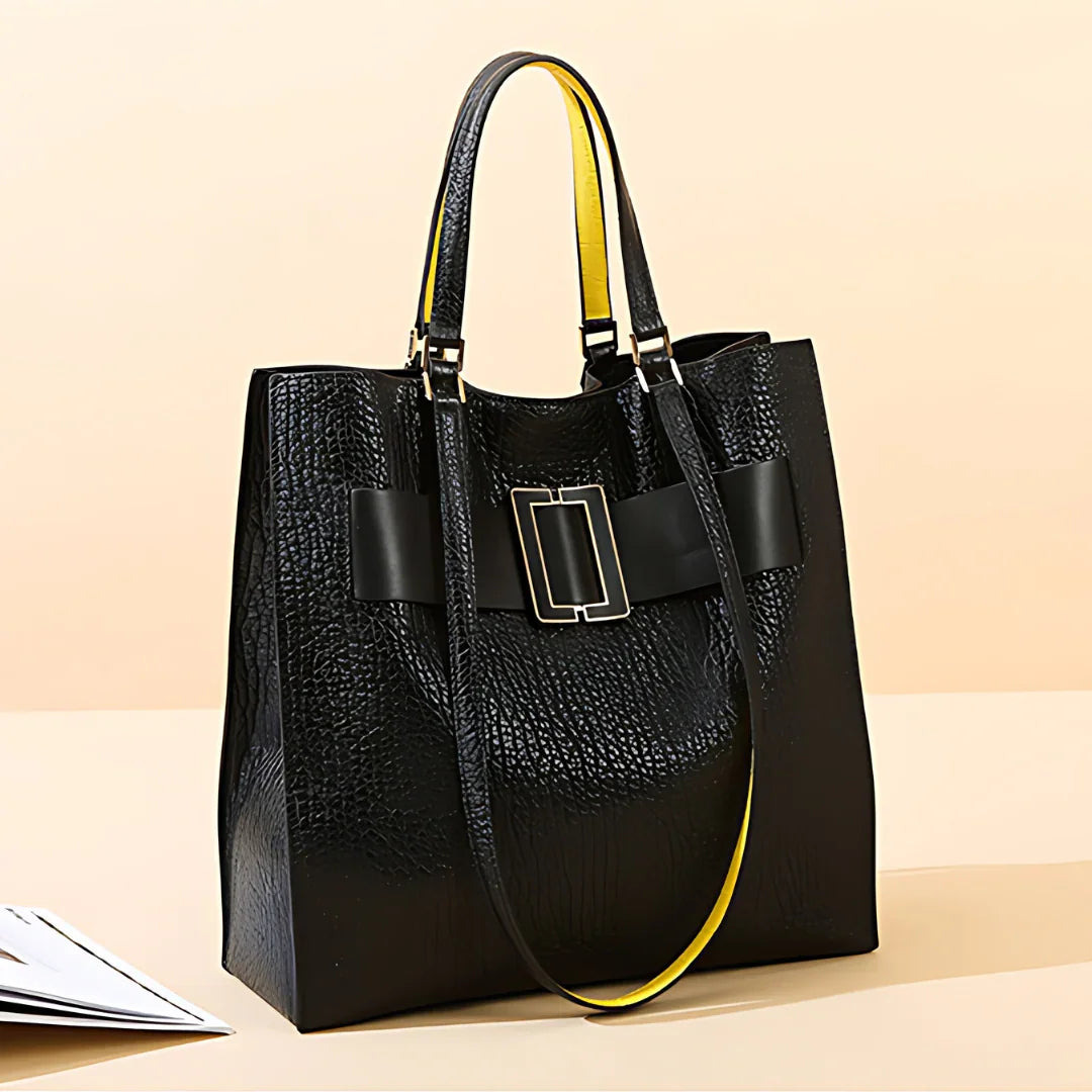 Black textured leather tote bag with yellow-lined handles and gold buckle accent