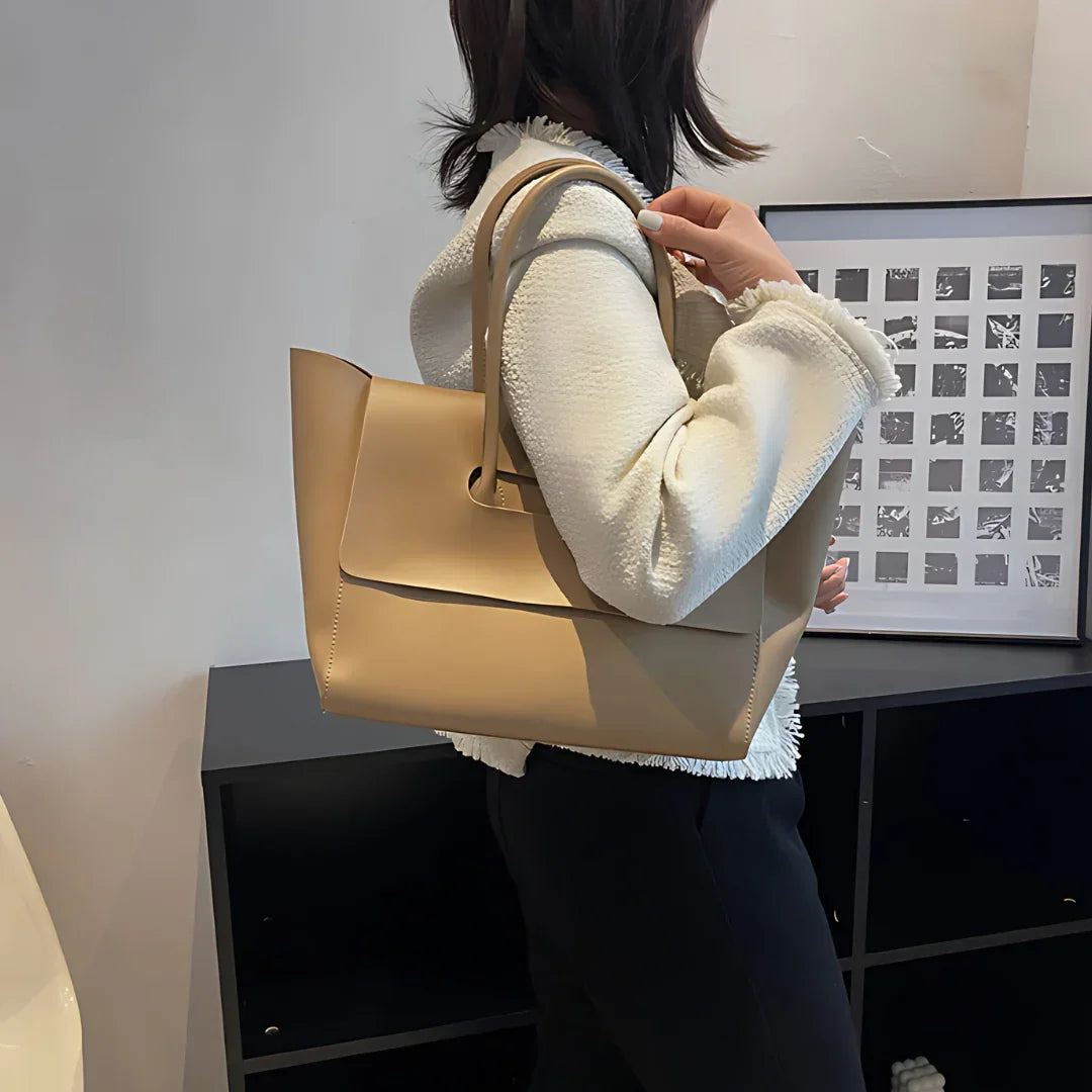 Woman wearing white jacket with beige leather tote bag, modern minimalist office decor