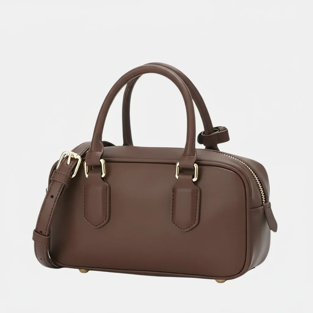Brown leather handbag with gold hardware, top handles, detachable strap on white background