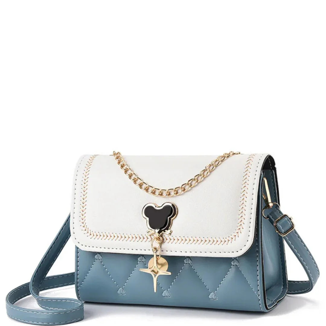 Blue and white crossbody purse with gold chain, bear-shaped charm, quilted design