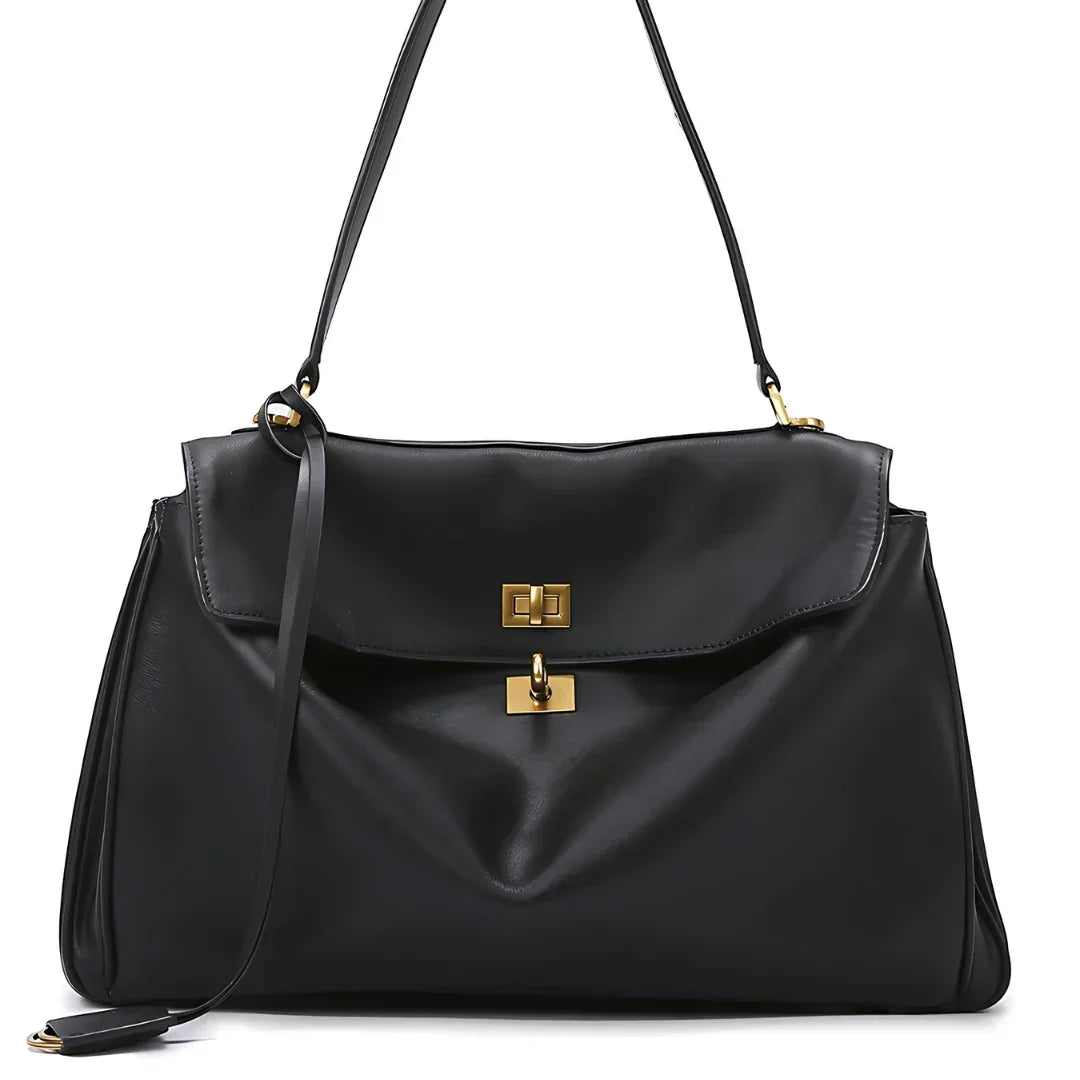 Black leather shoulder bag with gold hardware and top handle on white background