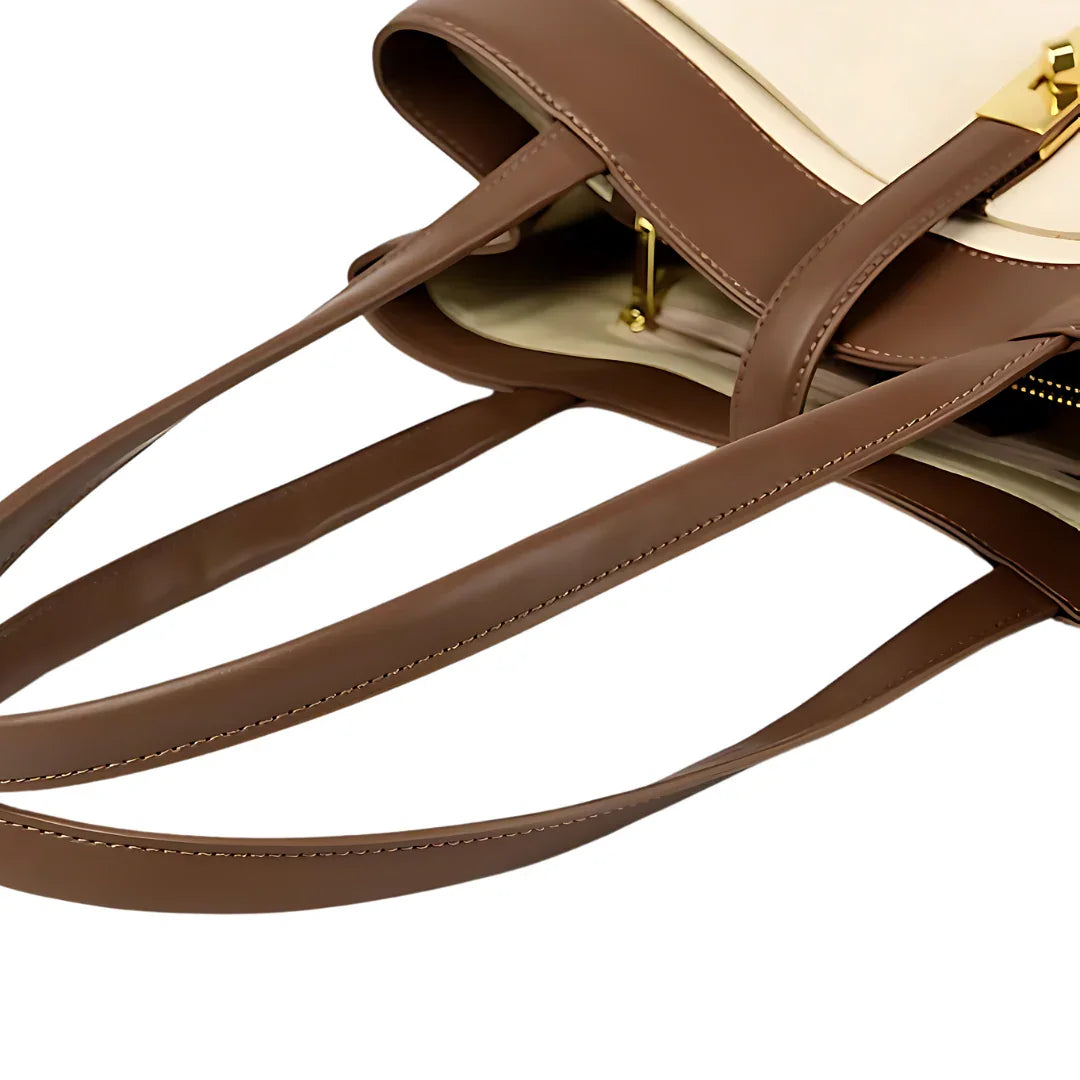 Brown leather designer tote bag with gold clasp and beige accents, close-up view