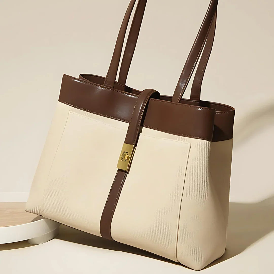 Beige and brown leather tote bag with gold clasp, double handles, and front pockets