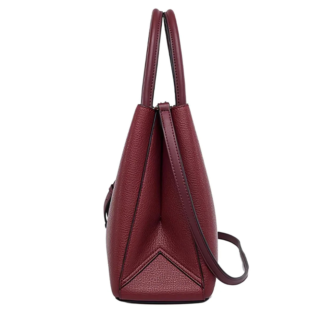 Side view of a maroon leather tote bag with dual handles and crossbody strap