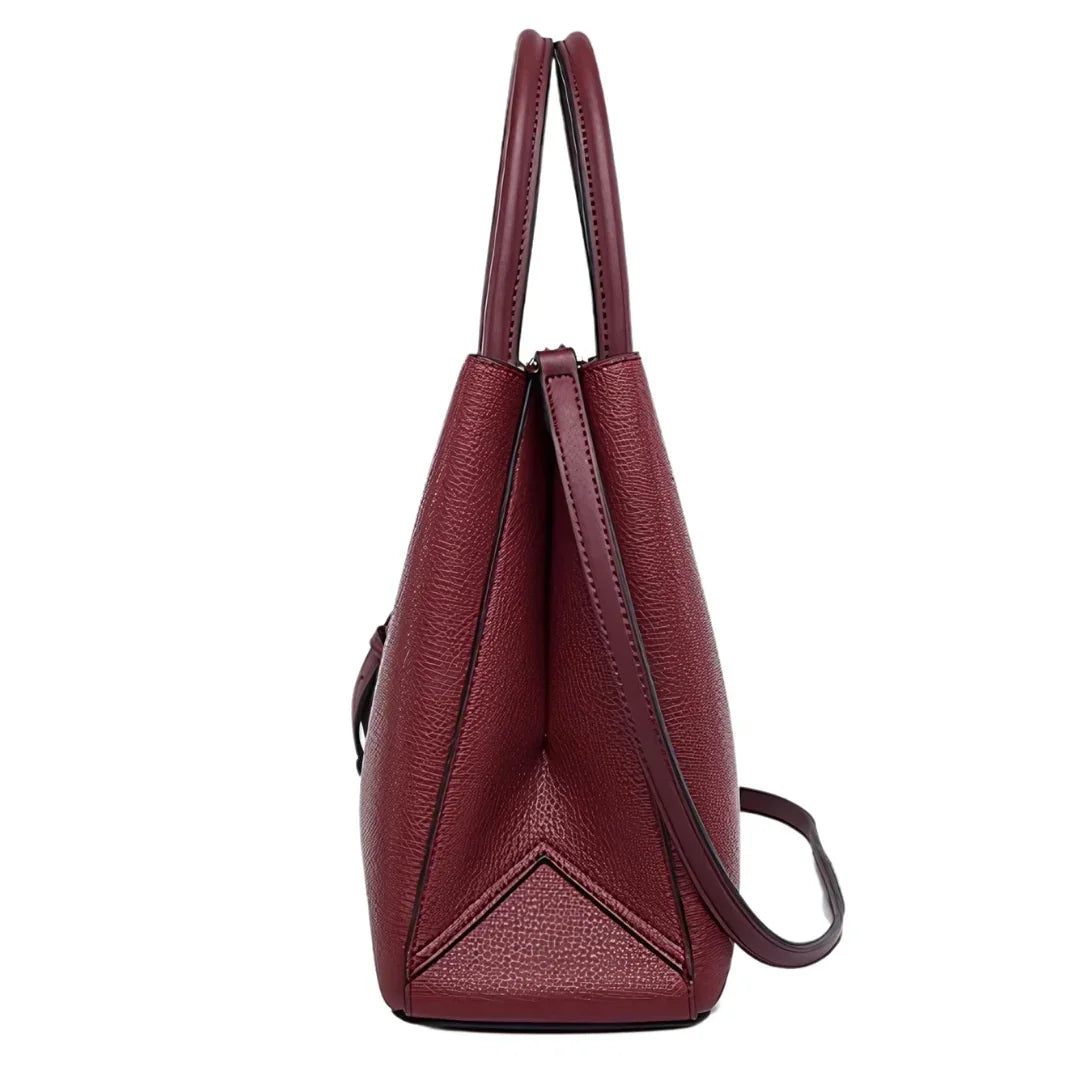 Side view of a maroon leather tote bag with dual handles and crossbody strap