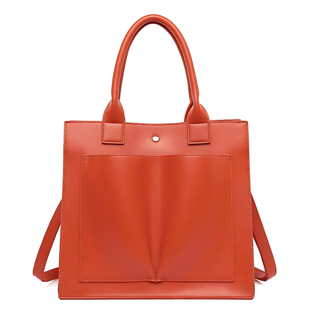 Orange leather tote bag with front pockets and double handles against white background