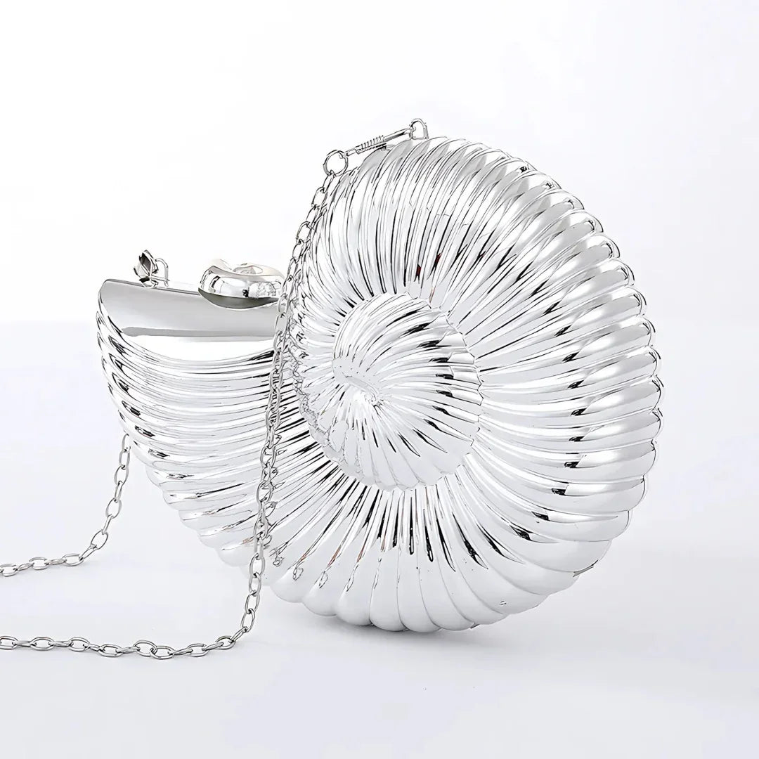 Silver seashell shaped clutch purse with chain on white background