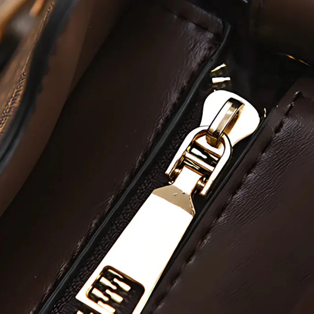 Close-up of a gold zipper on a dark brown leather handbag