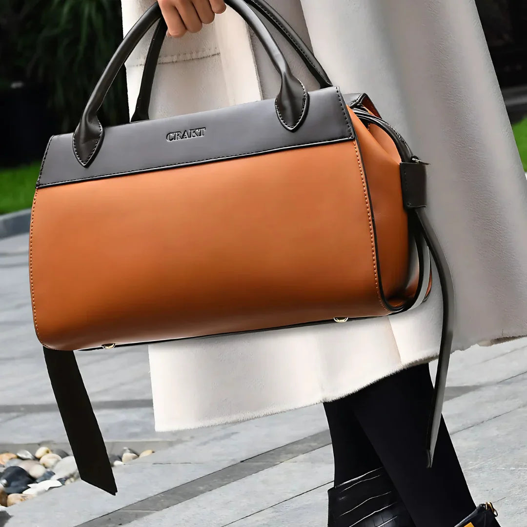 Woman carrying a stylish two-tone brown leather handbag outdoors