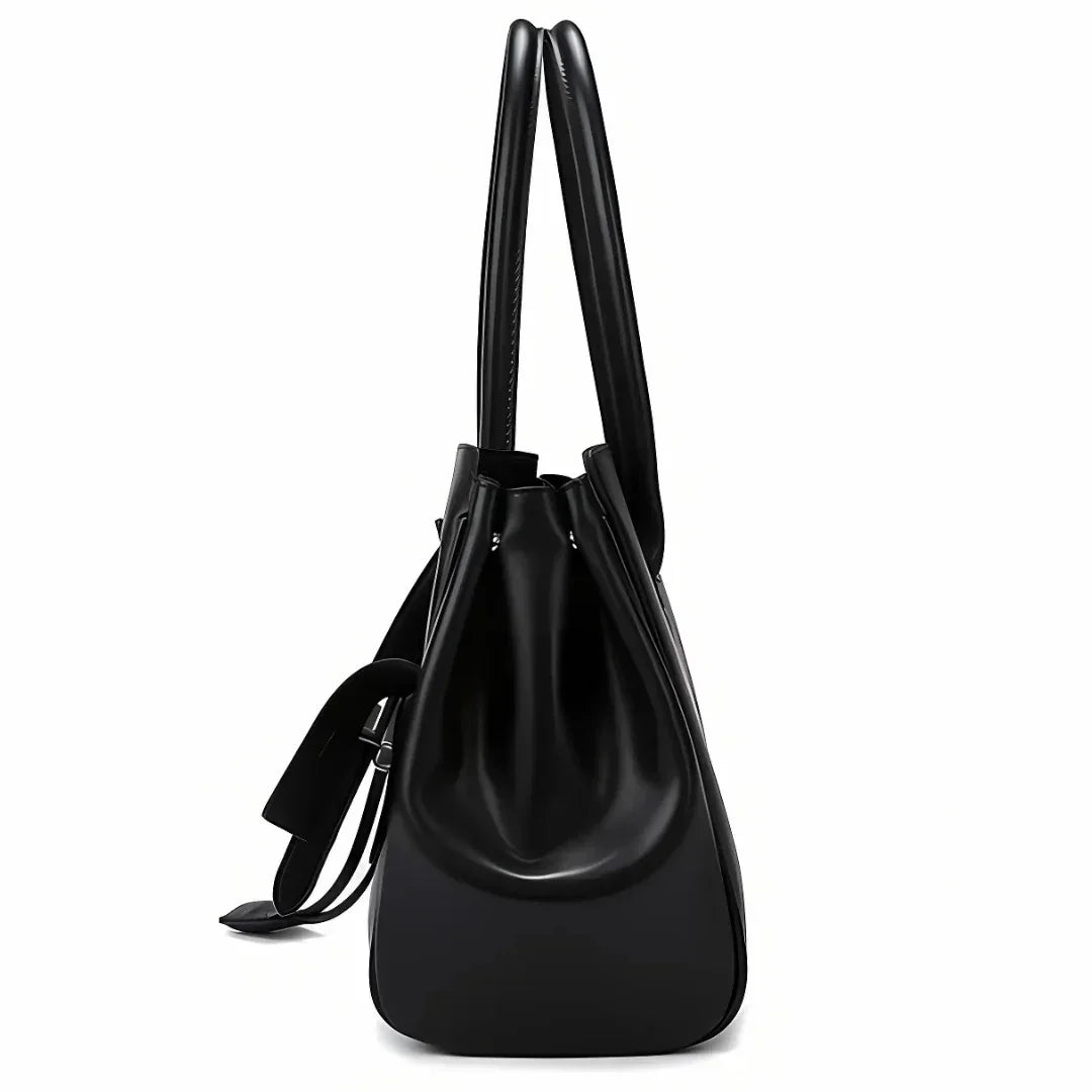 Side view of black leather tote bag with double handles and drawstring detail