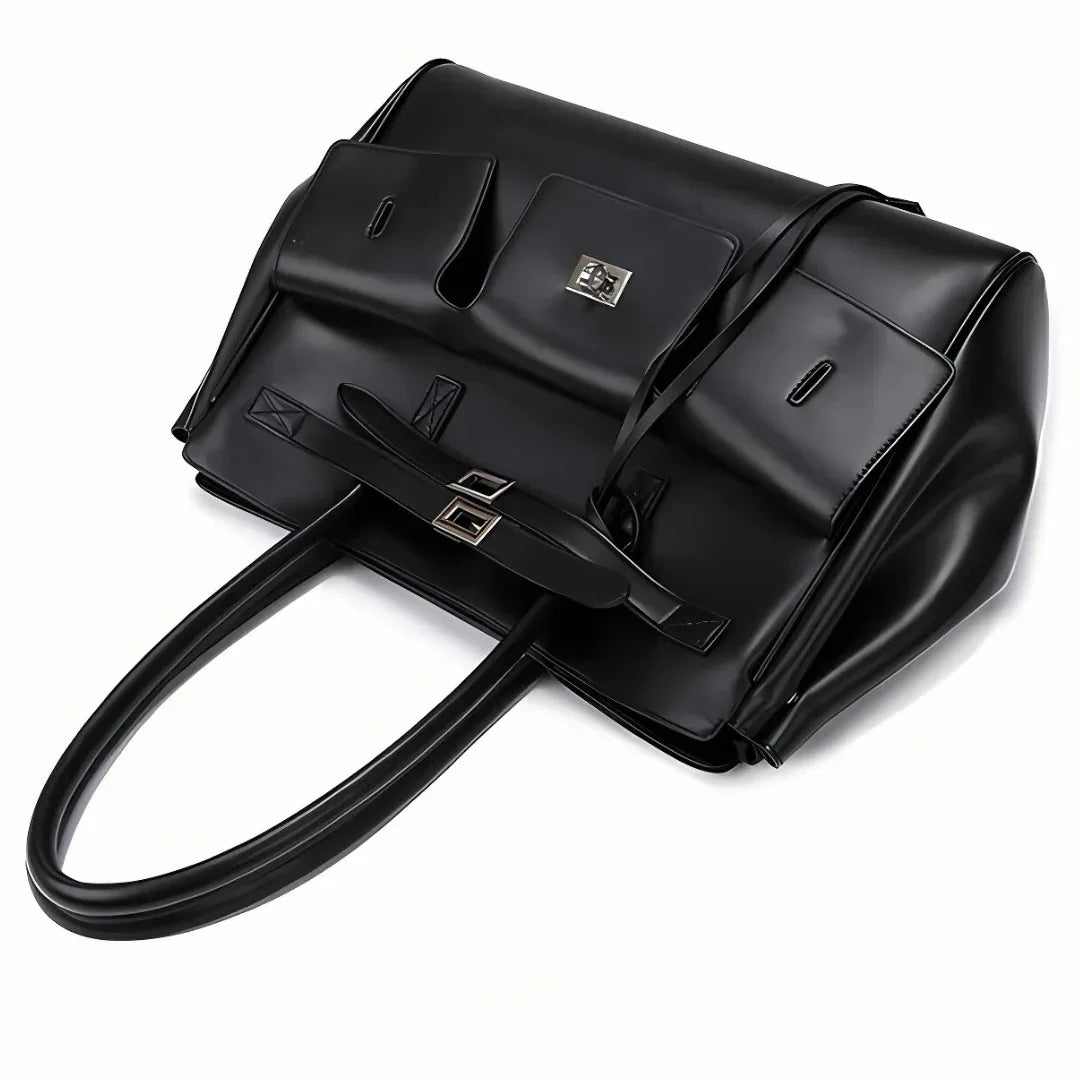 Oversized black leather handbag with long handles, silver hardware, and front pockets