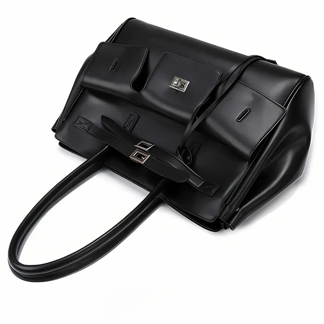 Oversized black leather handbag with long handles, silver hardware, and front pockets