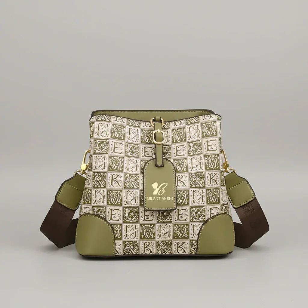Green and beige MILANTIANSHi patterned crossbody handbag with gold hardware on grey background
