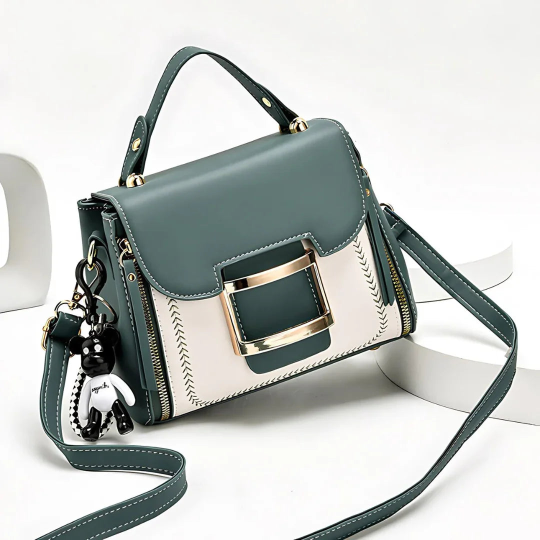 Stylish green and white handbag with gold buckle, top handle, shoulder strap, and bear keychain