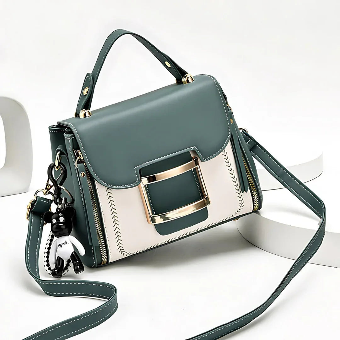 Stylish green and white handbag with gold buckle, top handle, shoulder strap, and bear keychain