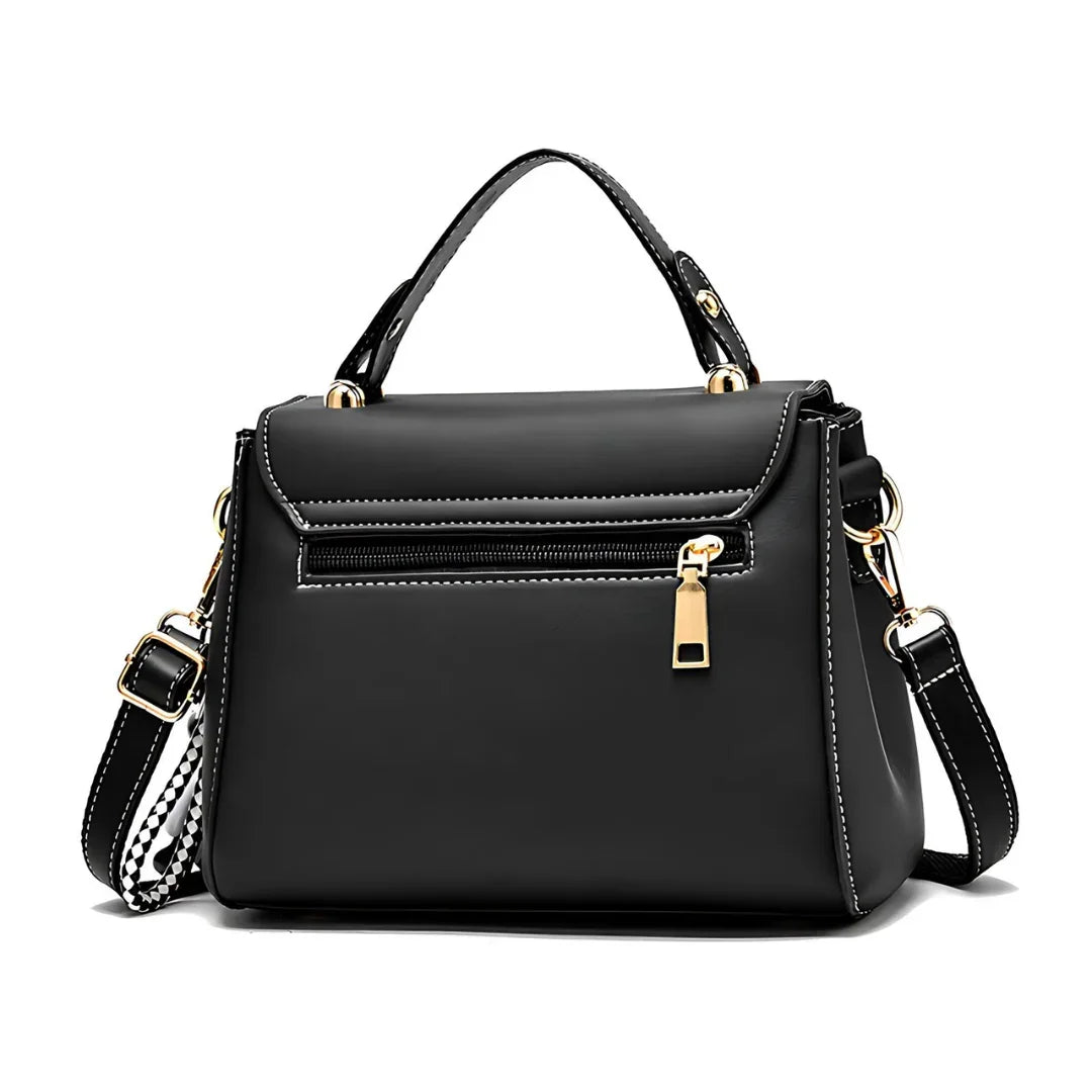 Black leather handbag with gold zipper, handle, adjustable strap, and white stitching