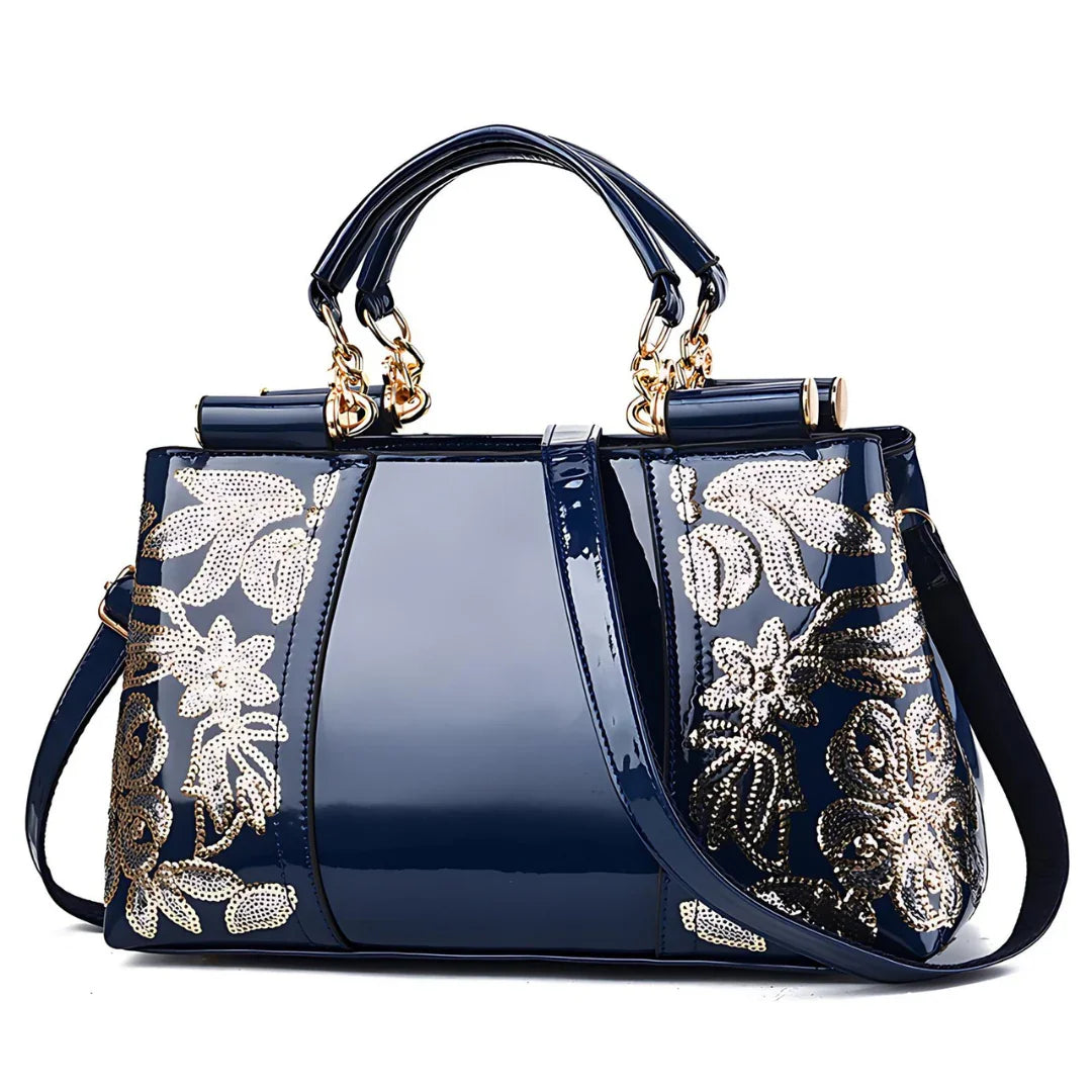 Shiny navy blue handbag with gold floral sequin accents and dual handles