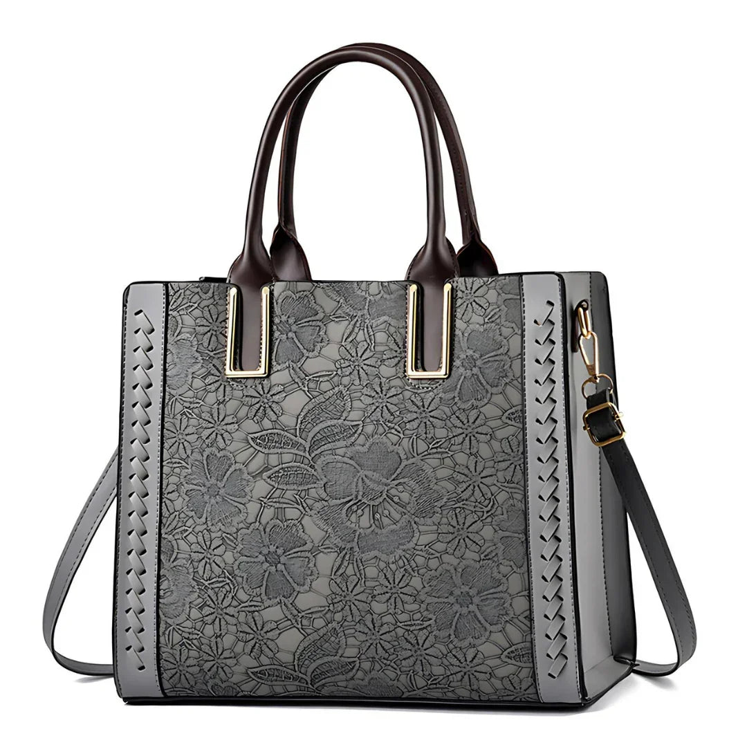 Gray floral embossed leather tote bag with dark brown handles and crossbody strap