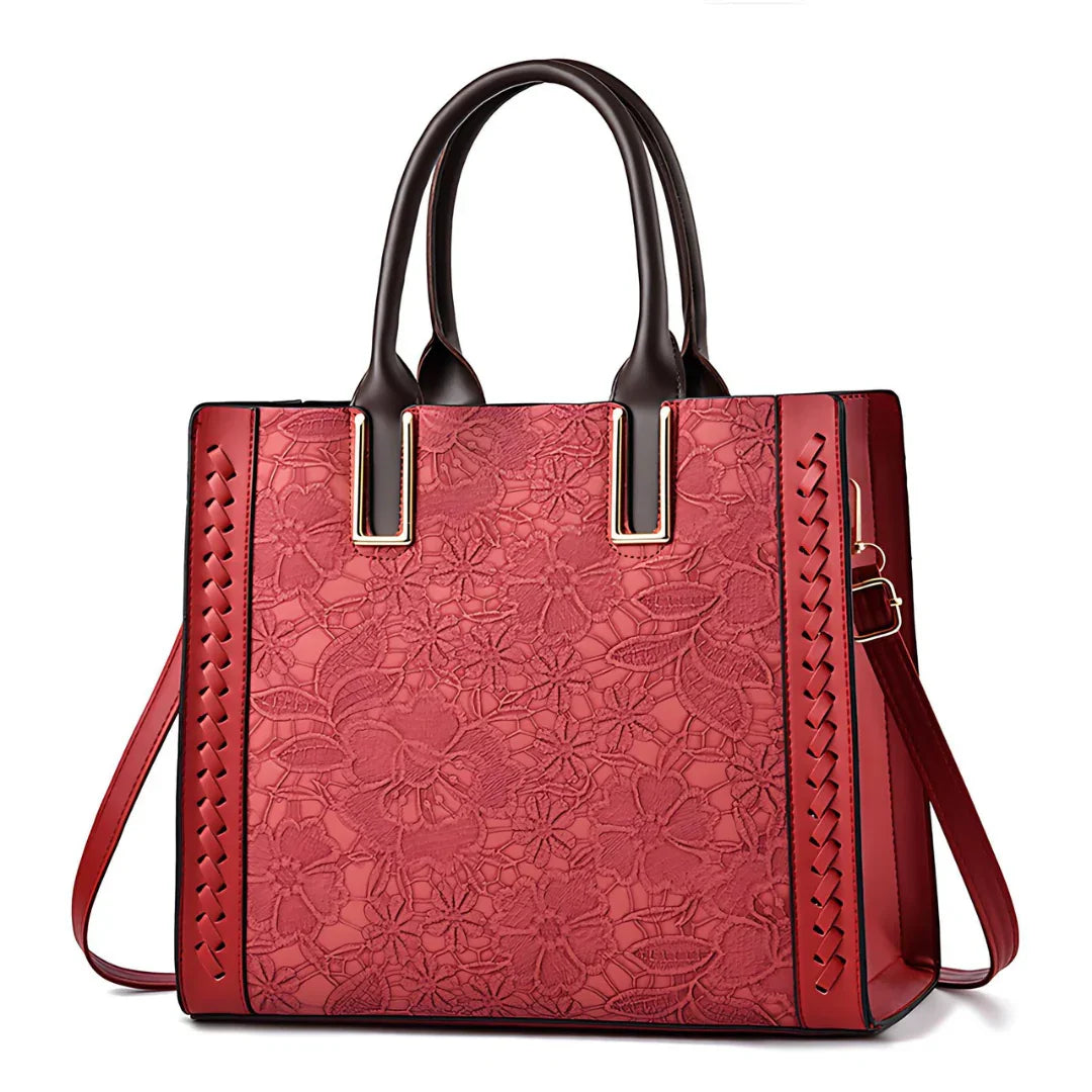 Red floral embossed leather tote bag with brown handles and gold hardware