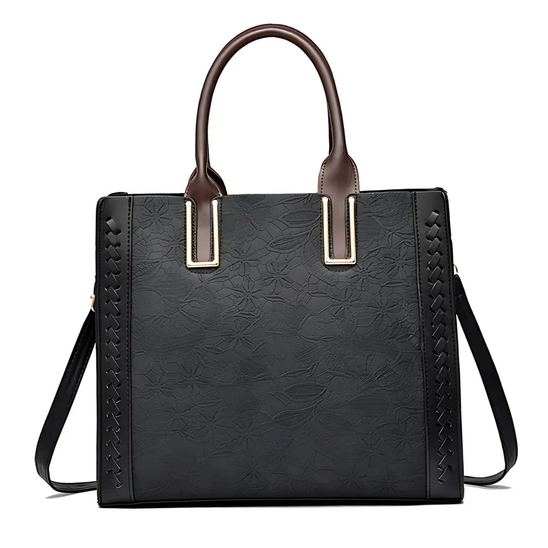 Black floral embossed tote handbag with brown handles and side braid detail