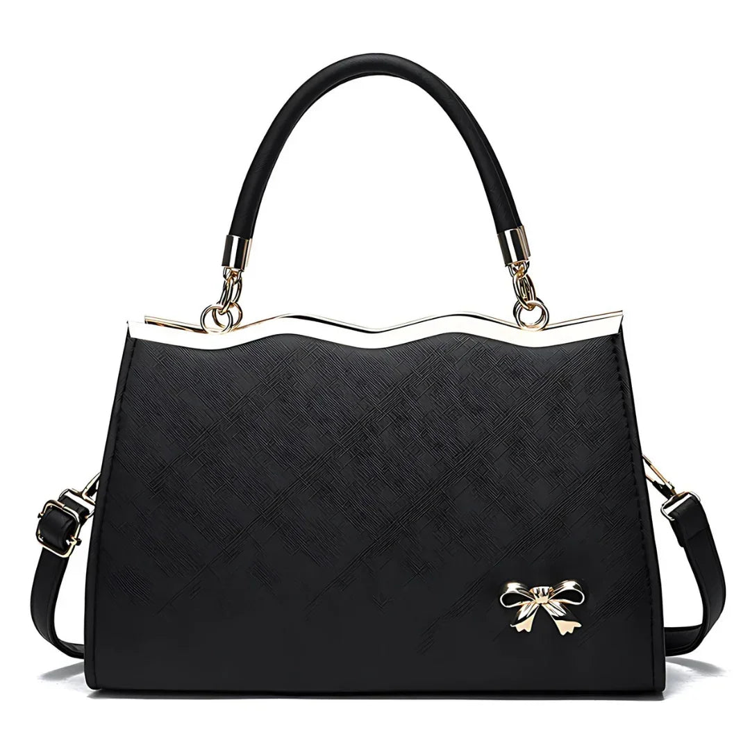 Elegant black handbag with gold handle accents and bow detail on white background
