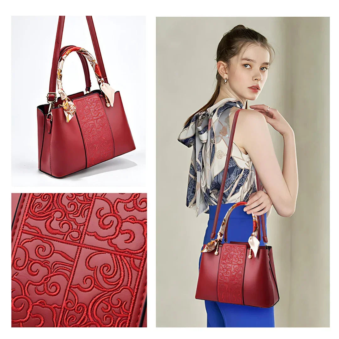 Elegant red leather handbag with embossed pattern and scarf handle, modeled by woman