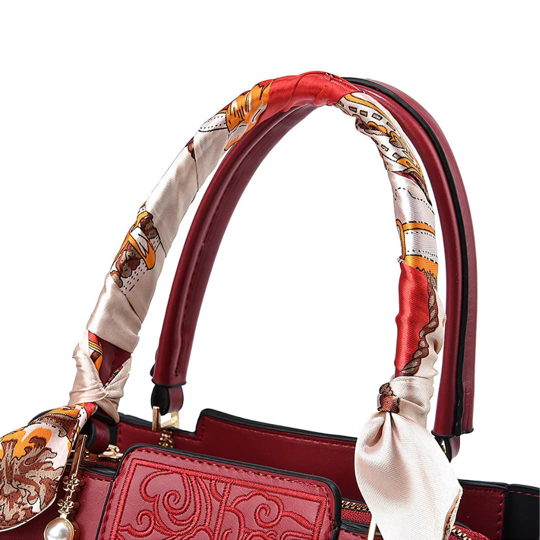 Red embossed leather handbag with patterned silk scarf wrapped handle