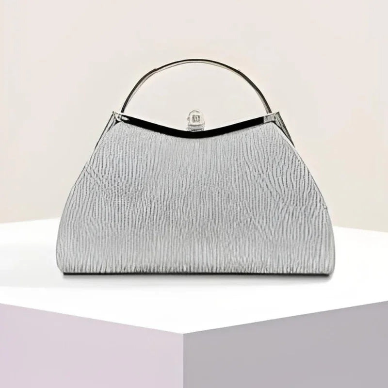 Textured silver handbag with metal handle on geometric white and pastel display
