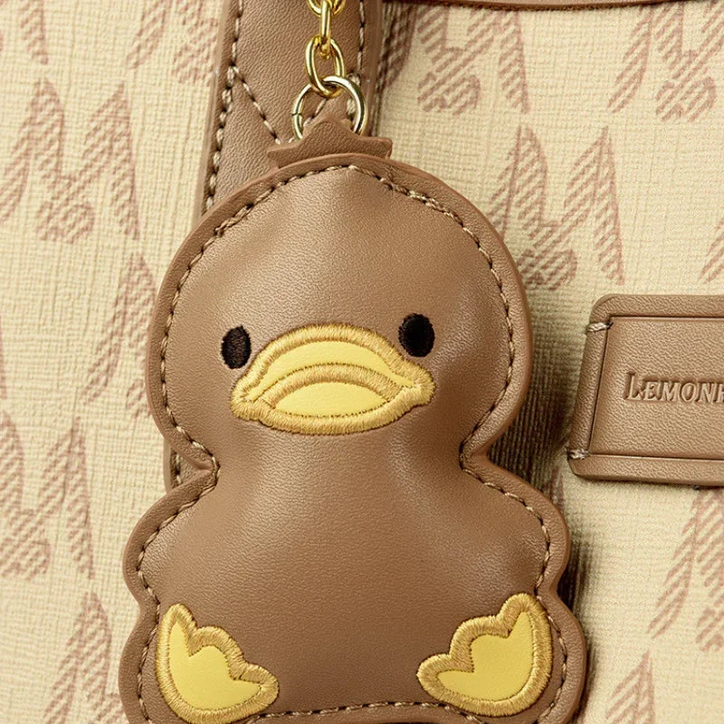Brown duck keychain on beige patterned bag with Lemon emblem branding