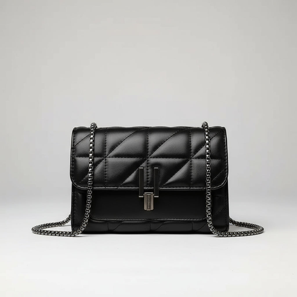 Black quilted leather crossbody bag with chain strap on white background