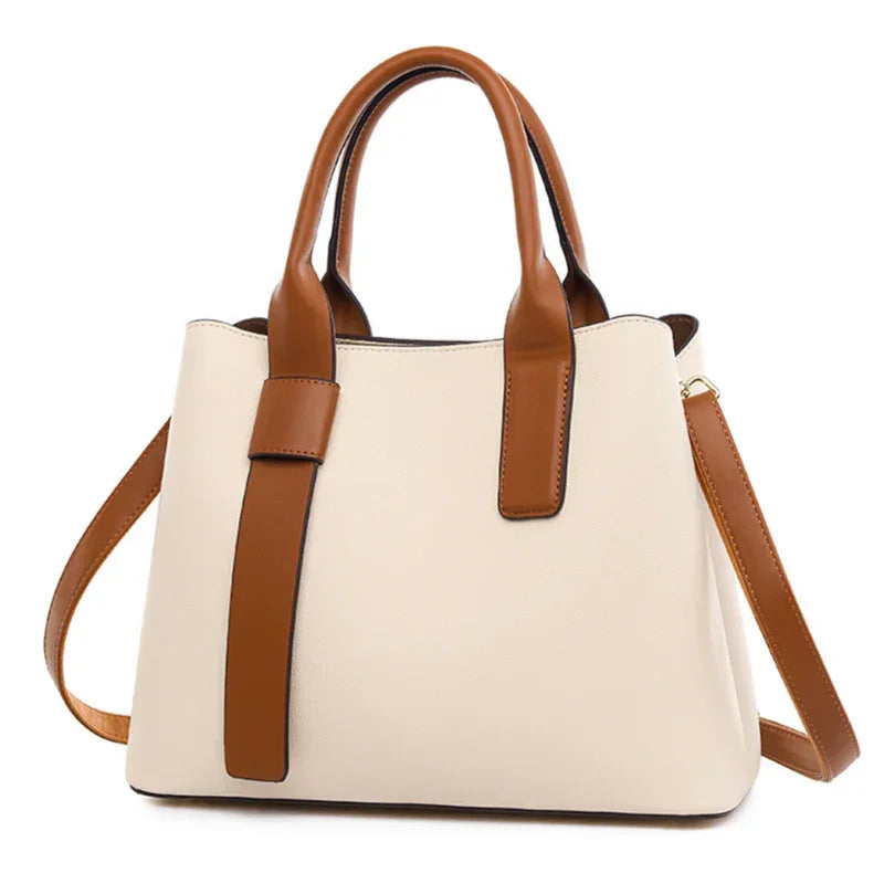 Beige and brown leather handbag with double handles and shoulder strap on white background